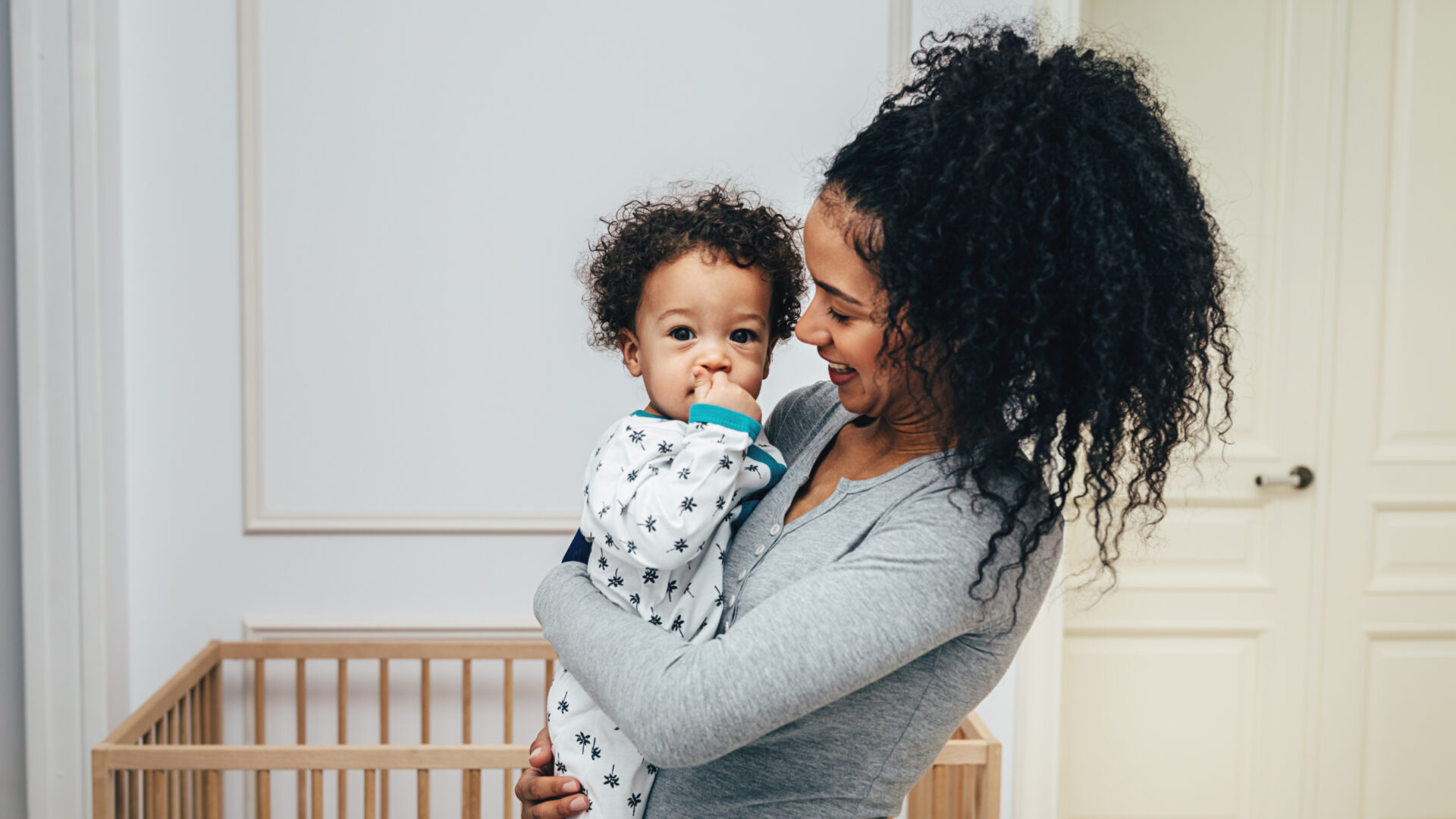 Smiling mother holding her child in living room