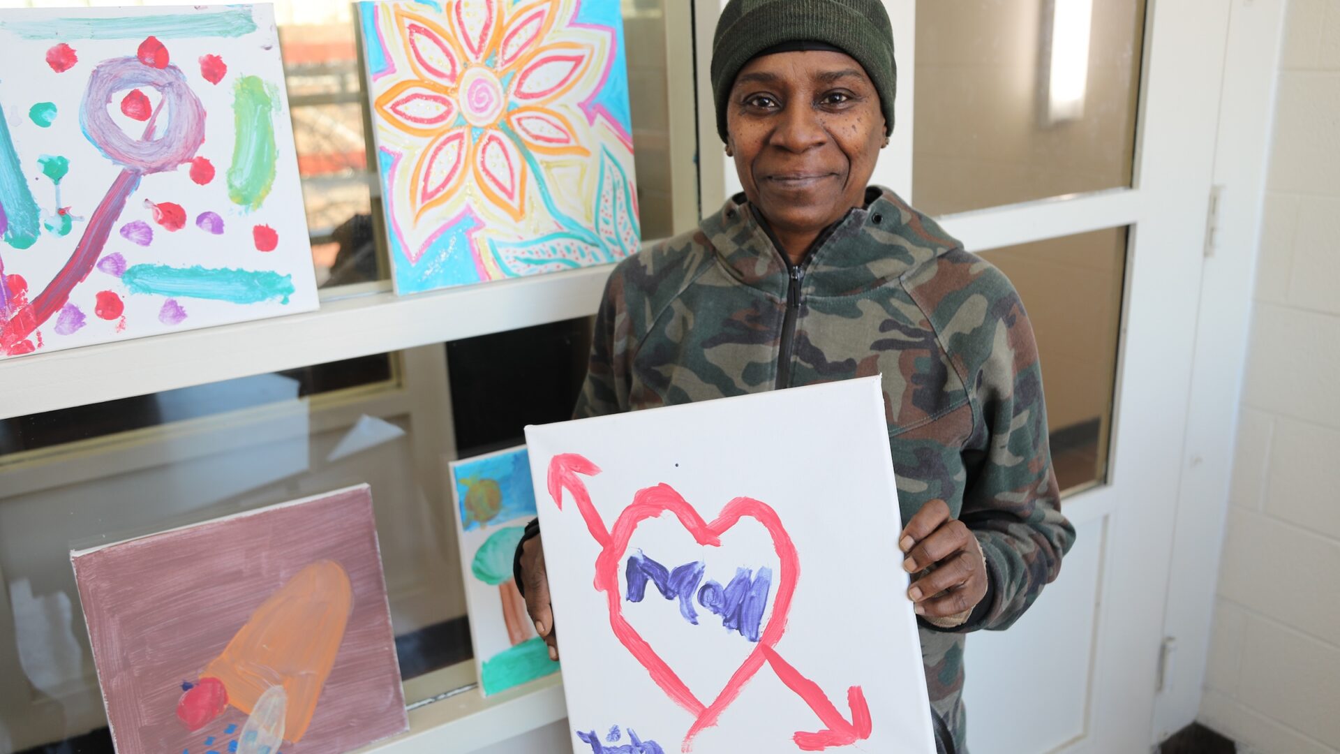 Female veteran holding up a painting.