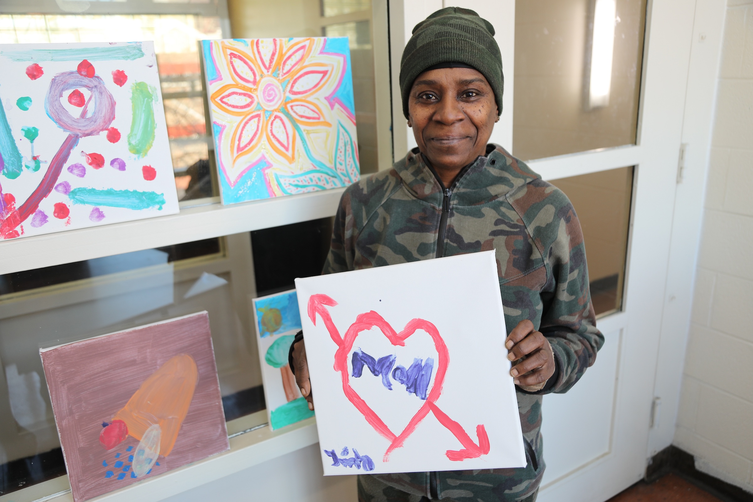 Female veteran holding up a painting.