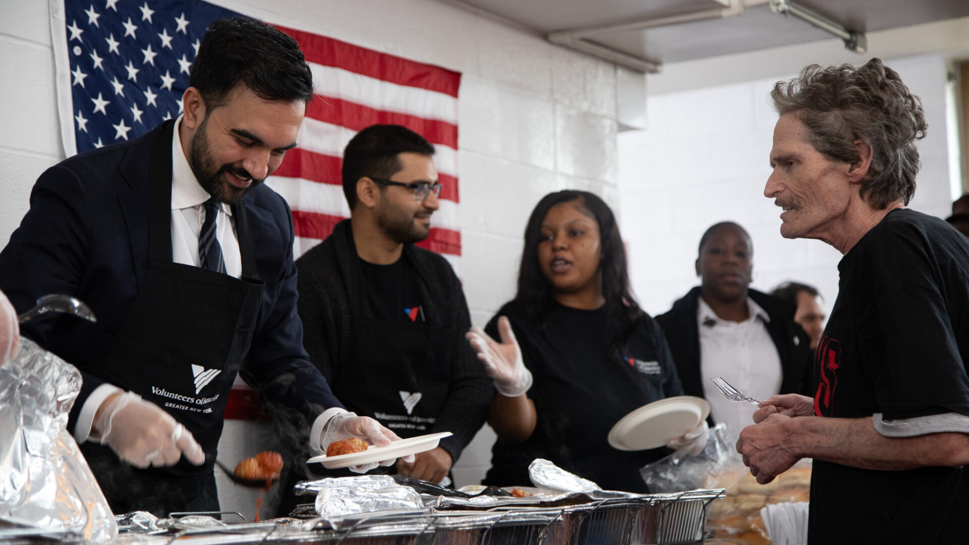 Mayor-elect Zohran Mamdani serving food at Commonwealth Residence in the Bronx.