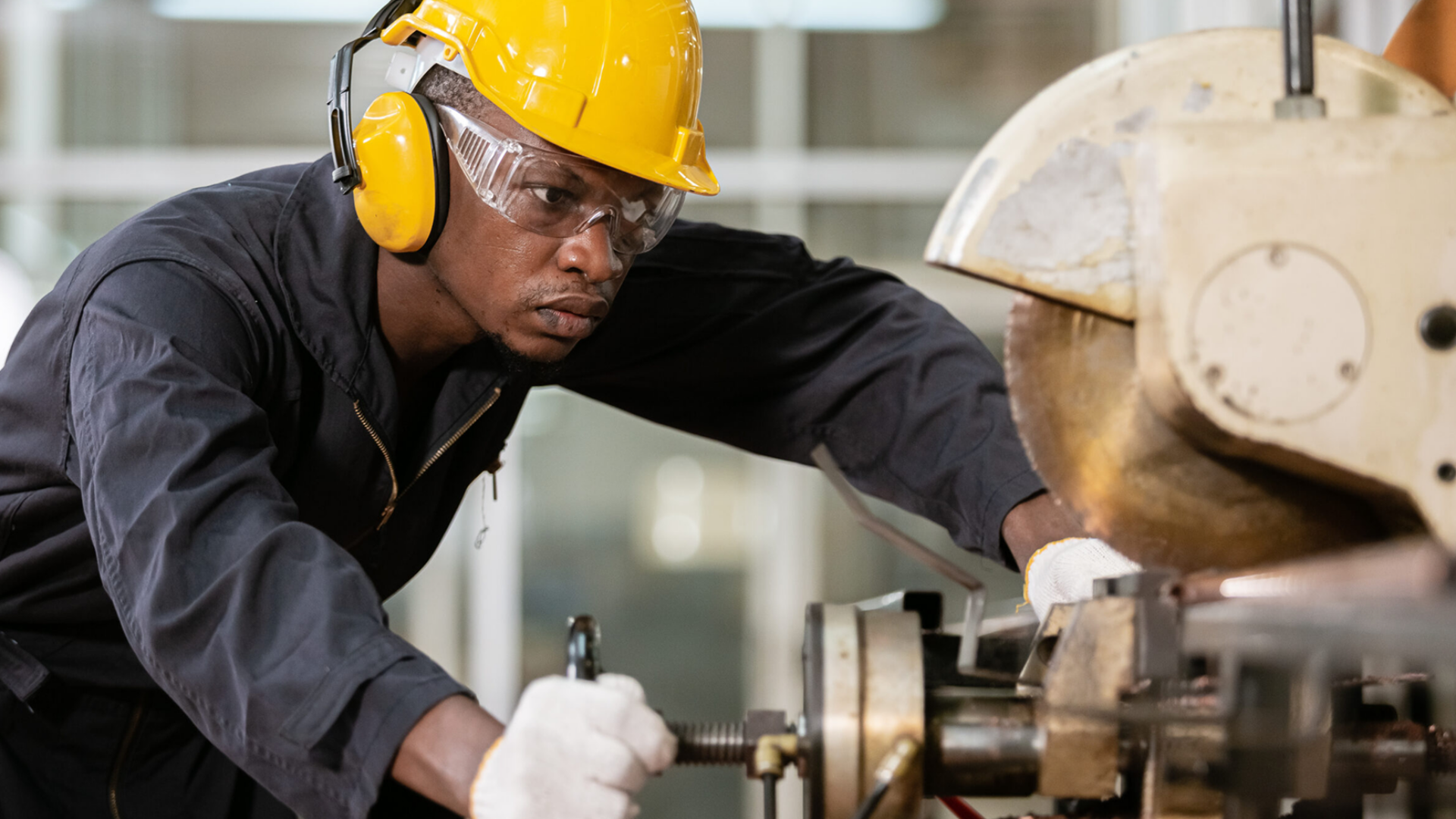 Worker using saw equipment and wearing a hard hat